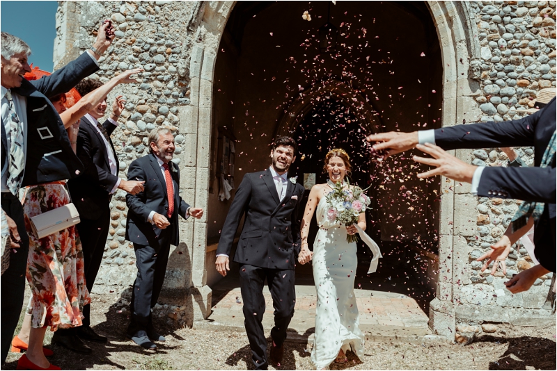Couple with confetti at micro wedding in Norfolk